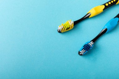 Toothbrushes. Oral care. Dental care. Composition with different toothbrushes on a blue background. Teeth love concept.Copy space. Place for text.Fletley