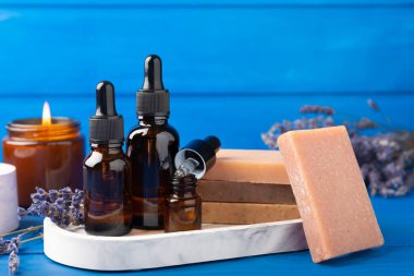 Temel yağlar ve el yapımı sabun. Mavi ahşap dokuda yanan mumlar. Lavanta kaplıcası. Gevşet. Metnin yeri. Kopya için yer. Dinlenme ve rahatlama..