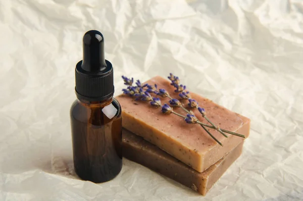 Lavender spa products and lavender flowers on beige texture background. Spa concept. Handmade soap, essential oil and lavender flowers.