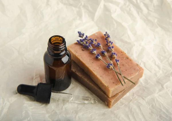 Lavender spa products and lavender flowers on beige texture background. Spa concept. Handmade soap, essential oil and lavender flowers.
