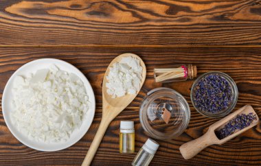 Ev yapımı mumlar. Kurumuş lavanta çiçekleri ve kahverengi arkaplandaki hoş kokularla dolu cam kavanozlar. Hobi. Dekor elementi. mesaj için yer. Kopyalanacak yer.