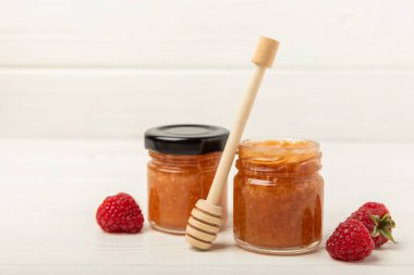 Bir kavanoz bal. Ahududu balı. Soğuk remedyal. Sağlık ve güzellik için kullanışlı güçlendirilmiş arıcılık ürünü. Krem balı. metin için yer