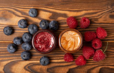 Bir kavanoz bal. Ahududulu ve yaban mersinli meyve balı. Sağlık ve güzellik için kullanışlı güçlendirilmiş arıcılık ürünü. Krem bal. Vejetaryen diyet organik ürün. metin için yer