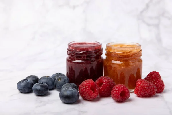 Jar of honey. Fruit honey with raspberries and blueberries.Useful fortified beekeeping product for health and beauty.Cream honey.Vegetarian diet organic product.Copy space. place for text