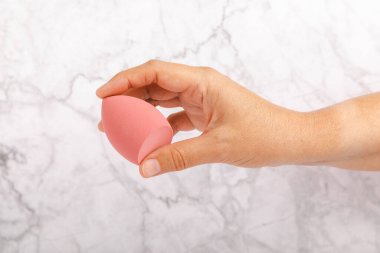 Güzellik blenderi, mermer bir duvarın arkasında duruyor. Makyaj malzemesi için sünger. Makyaj ürünleri. Güzellik konsepti. Mesaj için yer. Kopya için yer var. Düz yatıyordu