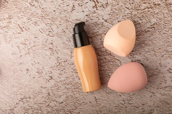Beauty blender with foundation cream on a marble background. Bright sponges for makeup cosmetics. Makeup products. Beauty concept. Place for text. Space for copy. Flat lay