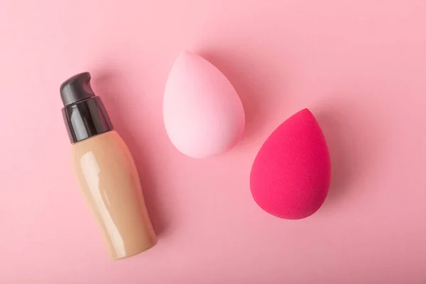 Beauty blender with foundation on a pink background.Bright sponges for makeup cosmetics. Makeup products. Beauty concept. Place for text. Space for copy. Flat lay