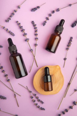 Cam bir şişede, pembe bir arka planda pipetle lavanta yağı. Kokulu yağlı bir şişe. Gerekli yağ modellemesi kopyalama alanı ile. Düz katman.serum. Kapat.