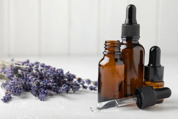 Essential oil of lavender in a glass bottle with a pipette on a white texture background.Bottle with fragrant oil. essential oil mockup with copy space.Flat lay.serum.Close up.