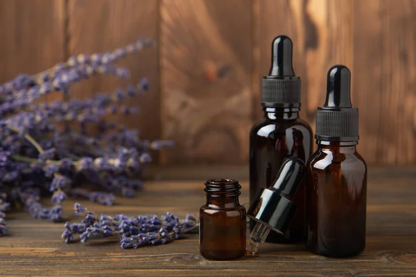 Essential oil of lavender in a glass bottle with a pipette on a brown textural background.Bottle with fragrant oil. essential oil mockup with copy space.Flat lay.serum.Close up.