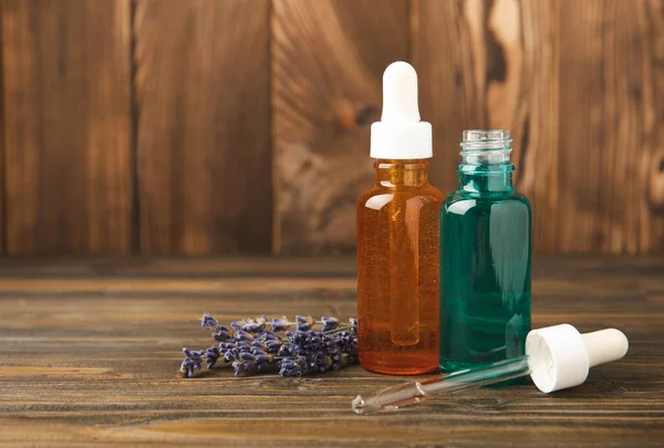 Essential oil of lavender in a glass bottle with a pipette on a brown textural background.Bottle with fragrant oil. essential oil mockup with copy space.Flat lay.serum.Close up.