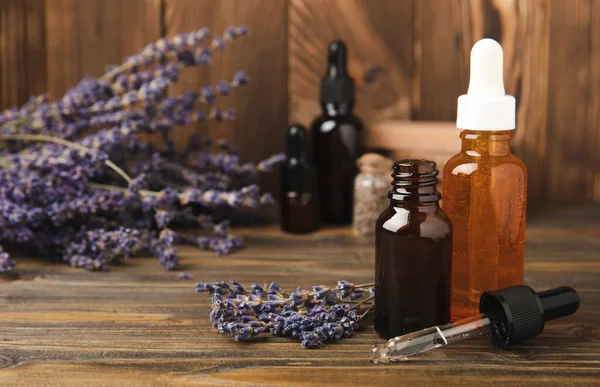 Essential oil of lavender in a glass bottle with a pipette on a brown textural background.Bottle with fragrant oil. essential oil mockup with copy space.Flat lay.serum.Close up.