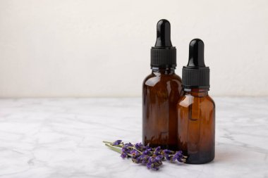 Cam bir şişede lavanta yağı ve beyaz dokuda bir pipet. Kokulu yağlı bir şişe. Gerekli yağ modellemesi kopyalama alanı ile. Düz katman.serum. Kapat.