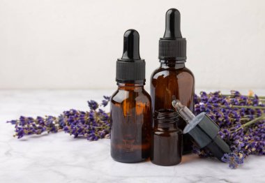 Cam bir şişede lavanta yağı ve beyaz dokuda bir pipet. Kokulu yağlı bir şişe. Gerekli yağ modellemesi kopyalama alanı ile. Düz katman.serum. Kapat.