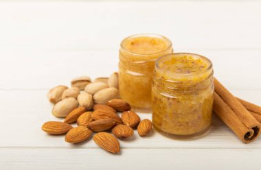 Beyaz tahtada fındık balı kavanozu. Soğuk algınlığı ilacı. Badem, fıstık, yıldız anason ve sağlık ve güzellik için tarçınlı kullanışlı güçlendirilmiş ürün. Vejetaryen diyet organik ürün. Boşluğu kopyala. Metin için yer