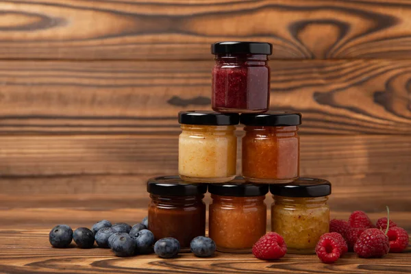Jar of honey. Fruit honey with raspberries, blueberries, almonds and pistachios. Useful fortified jam for health and beauty. Honey cream. Vegetarian diet organic product. Copy space.