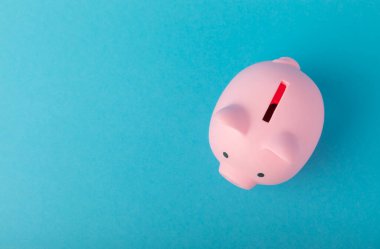 Mavi arka planda bir kumbara. Yatırım ve tasarruf kavramı. Yatırımlar. Kopyalanacak yer. maketleme