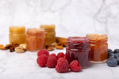 Bir kavanoz bal. Ahududulu, yaban mersinli, bademli ve şam fıstıklı meyve balı. Sağlık ve güzellik için reçeller. Bal kreması. Vejetaryen diyetinin organik ürünü. Uzayı kopyala. Uzayı kopyala.