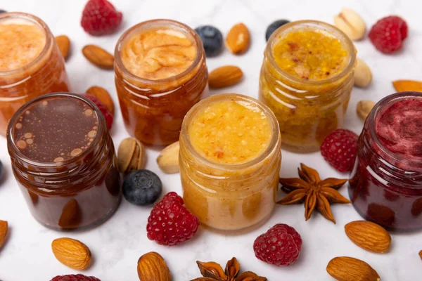 Jar of honey. Fruit honey with raspberries, blueberries, almonds and pistachios. Jams for health and beauty. Honey cream. Organic product of a vegetarian diet. Copy space.Copy space.