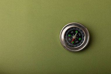 Yeşil doku arka planında klasik yuvarlak pusula. Pusula ile turizm kavramı. Bir pusula ile seyahat et. Pusulalı tatil ya da açık hava aktiviteleri. Mesaj için yer. Boşluğu kopyala