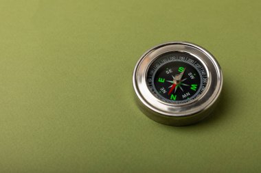 Yeşil doku arka planında klasik yuvarlak pusula. Pusula ile turizm kavramı. Bir pusula ile seyahat et. Pusulalı tatil ya da açık hava aktiviteleri. Mesaj için yer. Boşluğu kopyala