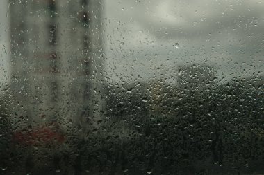 Fırtınanın arka planında yağmur damlaları olan cam. Şehrin arka planında yağmur damlaları. Tasarım için MOCKUP.Fotoğraf