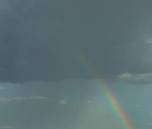 Rainbow on the background of a cloudy stormy sky. Banner. Nature.