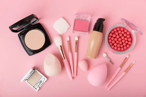 Makeup accessories,beauty blender and makeup brushes.Powder,foundation,eyeshadow and blush on pink texture background.beauty and fashion. Beauty concept