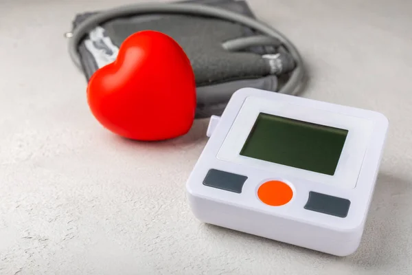 Blood pressure monitor and toy heart on white texture background. Medicine concept. Health care and medicine.Place for text.Space for copy.