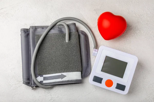 Blood pressure monitor and toy heart on white texture background. Medicine concept. Health care and medicine.Place for text.Space for copy.