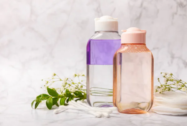 Micellar water, make-up remover with cotton pads. TONIC. Skin cleansing from sebum and makeup. Composition on a white marble background. Beauty concept. Copy space text. flat lay