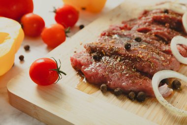 Soğan ve biberli taze çiğ biftek. Arka planda taze sebzeler. Et salamurası. Biftek..