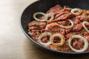 Kızartma tavasında soğan ve biberli taze sığır bifteği. Biftek..