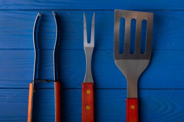 Mavi desenli arka planda kullanılmış barbekü araçları.