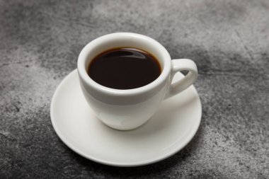 Koyu arkaplanda bir fincan kahve. Arka planda sıcak kokulu kahve. Kopyalama alanı için yer. Metin için yer. Düz yatıyordu.