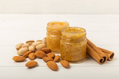 Beyaz tahtada fındık balı kavanozu. Soğuk algınlığı ilacı. Badem, fıstık, yıldız anason ve sağlık ve güzellik için tarçınlı kullanışlı güçlendirilmiş ürün. Vejetaryen diyet organik ürün. Boşluğu kopyala. Metin için yer