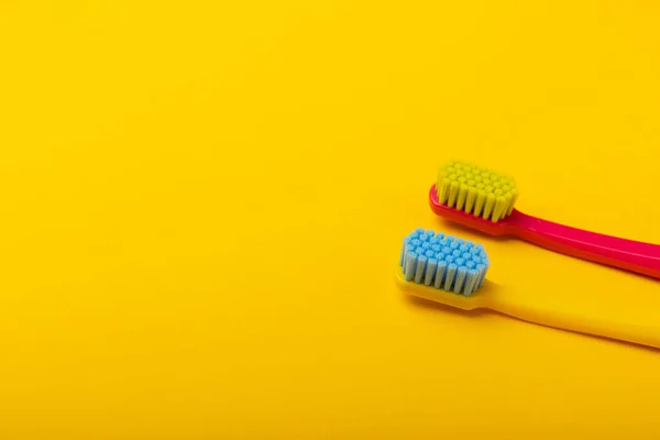 Toothbrushes. Oral care. Dental care. Composition with bright toothbrushes on a yellow background.Professional dental care. Copy space. Place for text.Fletley