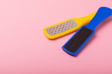 Pedikür aletleri. Pembe arka planda sünger taşı ve ayak dosyası. Yakın plan. Lastik patladı. Metin için boşluk, kopyalamak için boşluk.