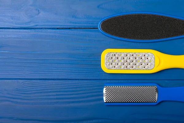 Pedicure tools. Pumice stone and foot file on blue texture background. Close-up. FLAT LAY. Space for text, space for copy.