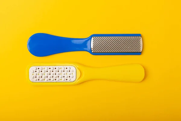 Pedicure tools.Pumice stone and foot file on a yellow background. Close-up. FLAT LAY. Space for text, space for copy.