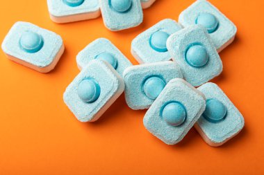 Turuncu arka planda su yumuşatıcı tabletleri. Metin için yer. Kopya için yer. Üst görünüm. Yakın plan.