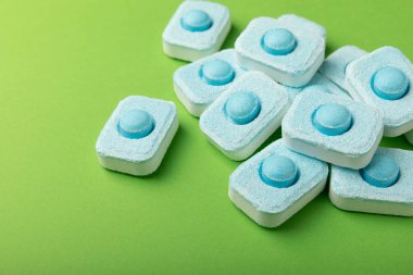 Yeşil arka planda su yumuşatıcı tabletleri. L.A.T. LAY. Metin için yer. Kopya için yer. Üst görünüm. Yakın plan.