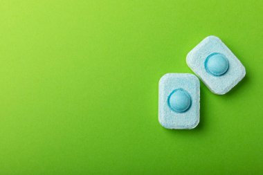 Yeşil arka planda su yumuşatıcı tabletleri. L.A.T. LAY. Metin için yer. Kopya için yer. Üst görünüm. Yakın plan.