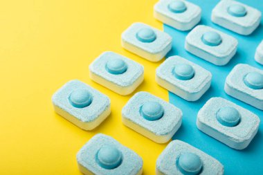 Sarı zemin üzerindeki suyu yumuşatmak için tabletler. Çamaşır makineleri ve bulaşık makineleri için kapsüller, kireçlenme ölçeğini engelliyor. Kopyalanacak yer.