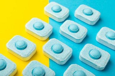 Sarı zemin üzerindeki suyu yumuşatmak için tabletler. Çamaşır makineleri ve bulaşık makineleri için kapsüller, kireçlenme ölçeğini engelliyor. Kopyalanacak yer.