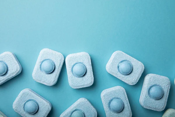 Water softener tablets on a blue background.FLAT LAY. Place for text.Space for copy.Top view. Close-up