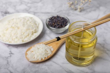 Ekolojik ve vejetaryen el yapımı soya mumları. Ahşap işlemeli mumlar. Şeffaf konteynır. Cam bir kavanozda soya cilası, gerekli yağlar, kurumuş çiçekler. Mum yapımı çatal bıçak. Vegan ürünü. Boşluğu kopyala..