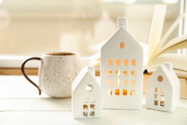 Mumlar ve şamdanların sonbahar kompozisyonu ahşap bir masa üzerinde minyatür ev. Noel dekoru. Rahatlatıcı ve durağan bir hayat. Konforlu iç dekorasyon.