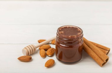 Beyaz tahtada fındık balı kavanozu. Soğuk algınlığı ilacı. Badem, fıstık, yıldız anason ve sağlık ve güzellik için tarçınlı kullanışlı güçlendirilmiş ürün. Vejetaryen diyet organik ürün. Boşluğu kopyala. Metin için yer