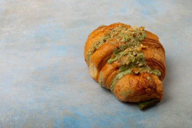 Mavi desenli taze kruvasan. Fıstık kabuklu ev yapımı lezzetli kruvasan. Mesaj için yer var. Kopyalanacak yer. Düz yatıyordu